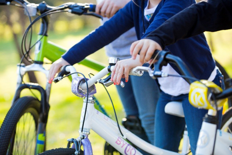 Hands holding bike handle bar brakes