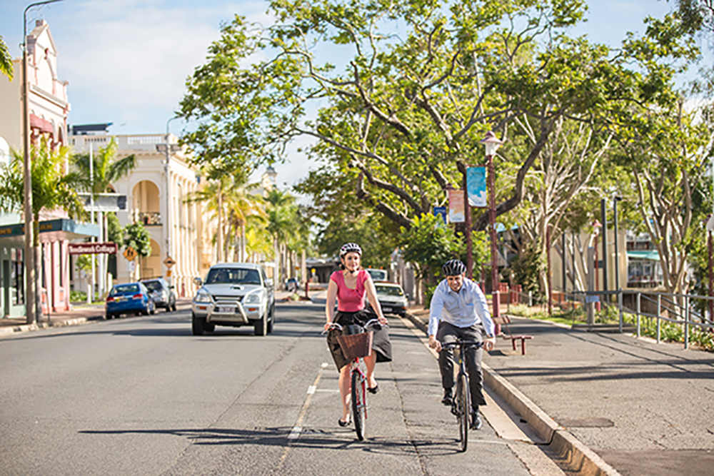 Two people riding on the left of the road. 