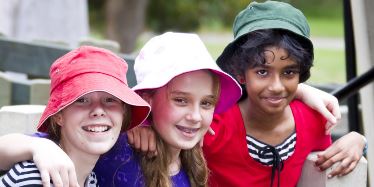 Three young girls hugging.