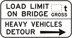 white sign with black arrow and text, load limit on bridge, number of tonnes gross. Heavy vehicles detour