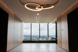 Circular lights intertwine like links in a chain over a wood-framed walkway