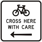 white sign with black icon of a bicycle, the words cross here with care, and an arrow