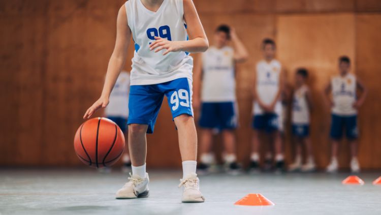 A child dribbling a basketball on a court