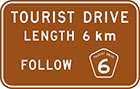 brown sign with white text, tourist drive length 6km follow route number