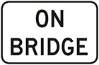 white sign with black text, on bridge