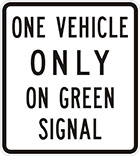 white sign with black text, one vehicle only on green signal