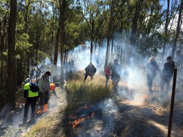 Photo of Conservation and Land Management students participating in a cultural burn with Bunya Peoples’ Aboriginal Rangers on Western Wakka Wakka country.