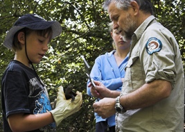 Photo of staff from the department teaching a volunteer to measure a Johnstone River snapping turtle.