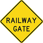 yellow diamond-shaped sign with black text, railway gate