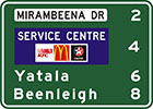 green sign with white panel with black text, Mirambeena Dr, distances listed in white and a blue panel with the words service centre and 3 company logos