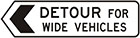 white sign with black arrow and text, detour for wide vehicles