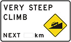 white sign with inset yellow diamond-shaped sign of black car driving up slope, as well as black text, very steep climb next number of km