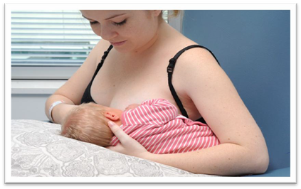 Mother holding her baby in an underarm (football) hold.