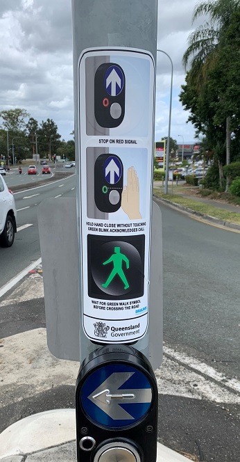 Sign at a touchless intersection showing how to activate by waving hand