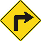 yellow diamond-shaped sign with black arrow that bends to the right at a right angle