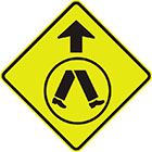 yellow diamond-shaped sign with black arrow and inset sign image of legs walking