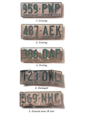 A selection of number plates showing different types of wear and tear including greying of colour, crazing and peeling of the surface, damage and general wear and tear to the number plate.