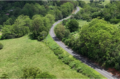 A photo of green hills and a two-lane road