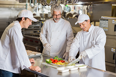 Teacher teaching students cooking techniques