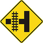 yellow diamond-shaped sign with black T shape with rail tracks, showing how they intersect the road