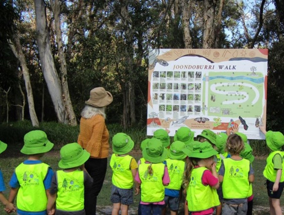 Children from Bribie Island Community Kindergarten gathered around the Joonoburri Walk map