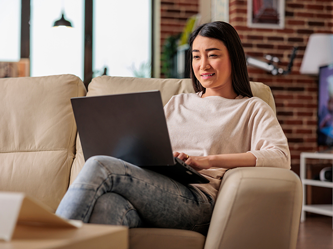 Woman at a house looking at a laptop