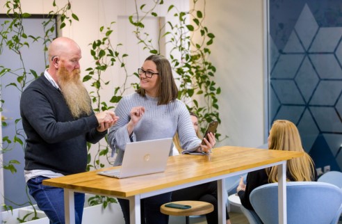 two people in an office using sign language to have a conversation