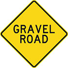 yellow diamond-shaped sign with black text, gravel road