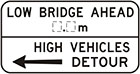 white sign with black arrow and text, low bridge ahead, number of metres. High vehicles detour