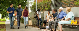 Photo of people outside a block of units.