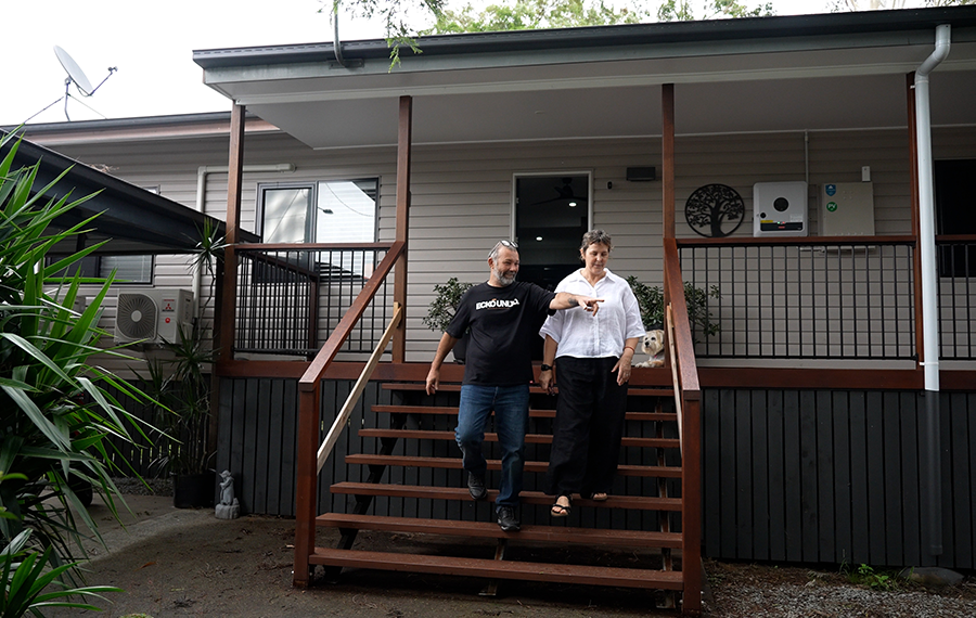 Couple walking down the front steps of their newly-raised cottage