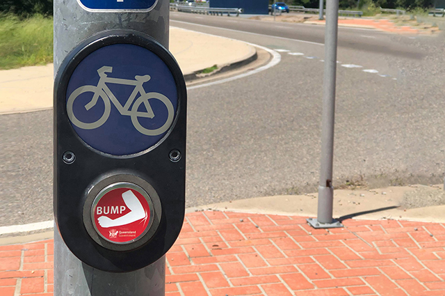 Pedestrian button with elbow bump sticker