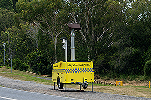 Yellow transportable speed camera on the roadside.