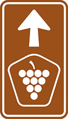 brown sign with arrow and pentagonal badge with grapes icon